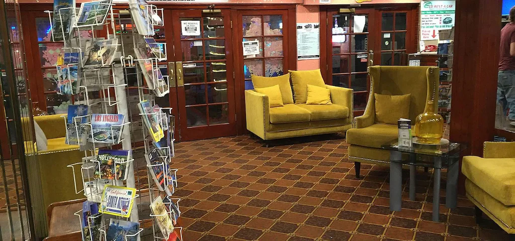 Cozy hotel lobby with yellow seating and a souvenir stand.